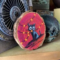 Holzscheibe handbemalt „Lichterkette auf Rot”